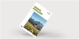 Ein Magazincover mit dem Titel "GOING MAGAZIN". Im Hintergrund sind Berge und eine Kirche in einer blühenden Landschaft zu sehen.