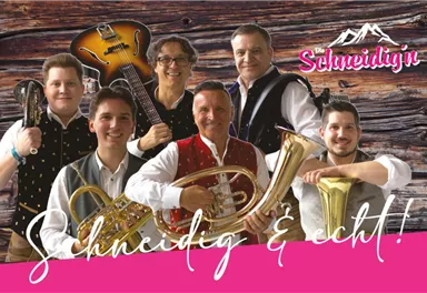 Eine Gruppe von sechs Musikern steht vor einer Holzwand. Sie tragen traditionelle Trachten und halten verschiedene Musikinstrumente.