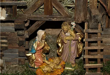 A nativity scene with figures that represent the birth of Jesus. The scene shows Mary, Joseph, and the newborn child in a lovingly arranged setting.
