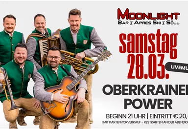 A music group in traditional outfits plays instruments. The text announces a live event at the Moonlight Bar in Söll.