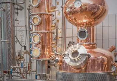 Eine Kupferdestille in einer Brennerei. Die Anlage zeigt moderne Technik zur Spirituosenherstellung.