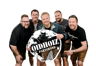A group of five men stands together holding a large sign of the band "OIDHOIZ". They are smiling and happily posing in athletic clothing.
