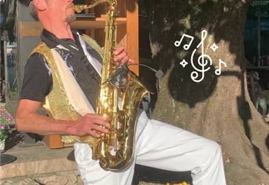 A lively music group outdoors, playing traditional instruments. In the background, guests can be seen in a relaxed atmosphere.