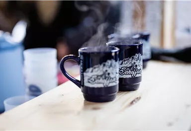 Steam cups on a wooden table. The cups are dark blue with a decorative print.