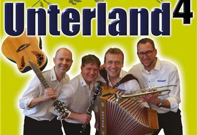 Eine Musikgruppe mit vier Mitgliedern hält verschiedene Instrumente in der Hand. Im Hintergrund ist der Schriftzug "Unterland4" und eine Berglandschaft zu sehen.