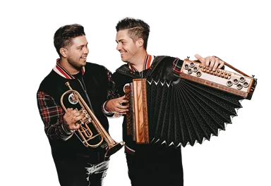 Zwei Musiker stehen nebeneinander und lächeln sich an. Der eine hält eine Trompete und der andere ein Akkordeon.