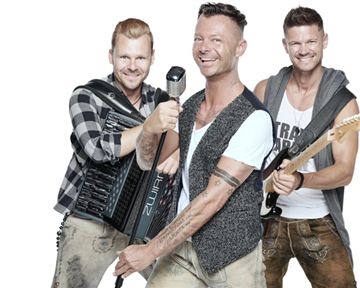 Three musicians are happily posing in front of a white background. They are holding various musical instruments and wearing casual clothing.