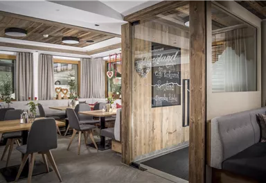 Ein einladendes Restaurant mit Holzdekor und gemütlichen Tischen. Der Raum ist hell erleuchtet und freundlich gestaltet.
