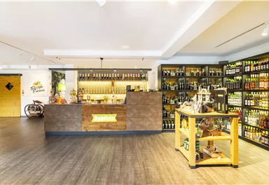 Ein modernes Geschäft mit einer gut sortierten Bar und Regalen voller Getränke. Die Holzregale und der Empfangstresen schaffen eine einladende Atmosphäre.