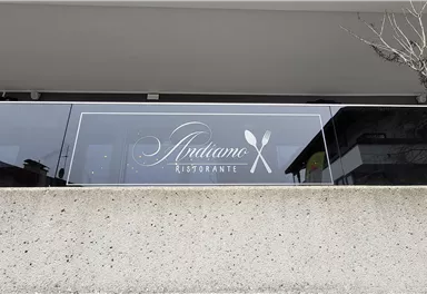 Ein modernes Restaurant-Schild mit dem Namen "Antlame". Die Fensterfront ist elegant und gut sichtbar.