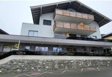 Ein modernes Gebäude mit mehreren Balkonen und einem geschmackvollen Design. Die Front ist stilvoll und einladend gestaltet.