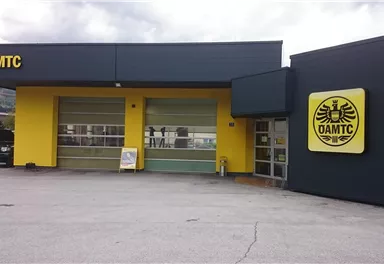 A modern building with a yellow and black facade. The ÖAMTC logo is clearly visible.