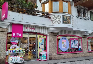 A store with the sign "BIPA" in a modern facade. The exterior view shows large windows and an inviting entrance door.