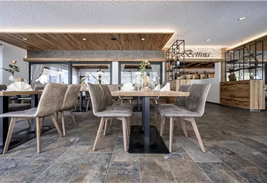 A modern restaurant with elegant tables and chairs. The decor is bright and cheerful, with wood and stone accents.