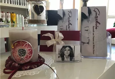 A cozy table decoration with a candle, brochures, and a framed photo. The colors are warm and inviting, perfect for a relaxing atmosphere.