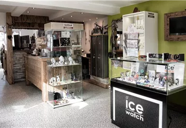 A modern store with jewelry and watches. The walls are painted green, and there is a cozy atmosphere.