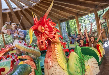 A colorful dragon park with cheerful children and a friendly knight. The atmosphere is lively and inviting.