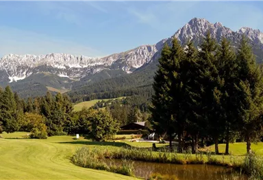 A picturesque landscape with mountains in the background and a tranquil pond. The surroundings are green and lush, perfect for outdoor activities.