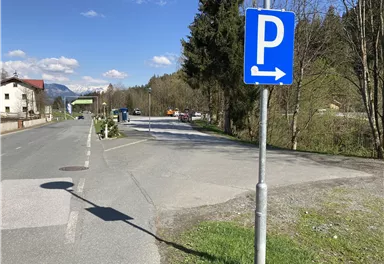 A parking lot is marked, with an arrow pointing to the right. In the background, trees and a quiet place can be seen.