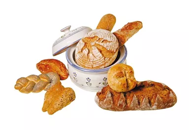 A selection of fresh bread in a bread basket. Various types of bread such as baguette, rolls, and rye bread are visible.