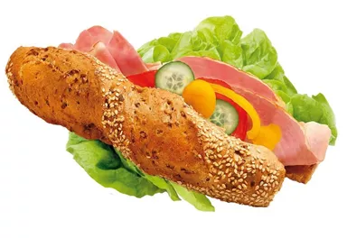 A fresh sandwich with a whole grain roll. It is topped with ham, vegetables, and lettuce.