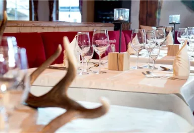 An elegant restaurant with beautifully set tables. The glasses and decorations create an inviting atmosphere.