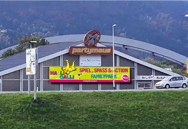 A large leisure and family center named "Partynau". The building has a prominent advertisement for games, fun, and action.