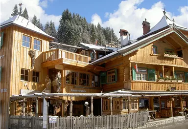 A traditional wooden architecture in a snowy mountain village. The buildings are adorned with interesting decorations and the surroundings are inviting.