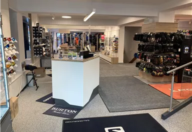 A modern sports store with various products for outdoor activities. The shelves are filled with equipment and accessories.