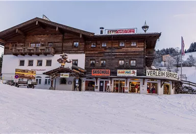 A typical mountain house in a winter ski resort. There are shops for ski equipment and a ski school service.