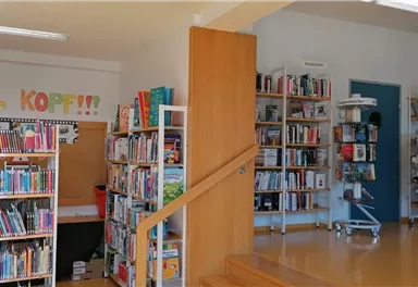 An inviting room with shelves full of books. On the wall is the inscription "Cinema in the Head."