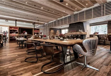 A modern restaurant with wood decor and a cozy atmosphere. The seating is stylish and the room is well-lit.