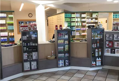 Eine moderne Apotheke mit Regalen voller Gesundheitsprodukte. Der Empfangsbereich ist einladend gestaltet und bietet eine breite Auswahl von Artikeln an.