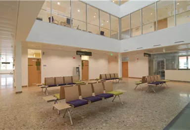 A bright waiting room with modern chairs and an open atmosphere. Large windows let in plenty of daylight.