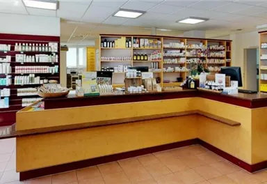 A bright pharmacy with shelves full of medication. The reception counter is clearly visible and designed to be welcoming.