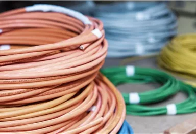 Colorful cable reels in various colors are lying on a table. The cables are neatly coiled and well visible.