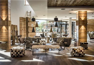 A stylish and modern living room with wooden decor and cozy furniture. Large windows let in plenty of light and create an inviting atmosphere.