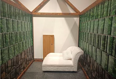 A stylish room with a white sofa and walls decorated with pictures of plants. The atmosphere feels calm and inviting.