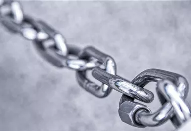 A shiny metal chain with clear connections. The focus is on the individual links of the chain.