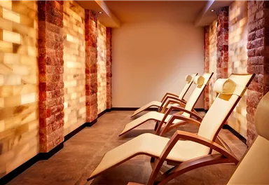 A relaxing space with comfortable loungers and soft light. The walls are designed in warm colors, creating a soothing atmosphere.