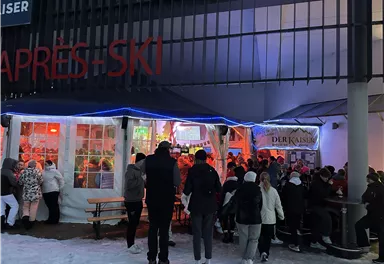A logo of "Der Kaiser," an après-ski bar in Scheffau. It features a stylized mountain and the lettering in golden and black colors.