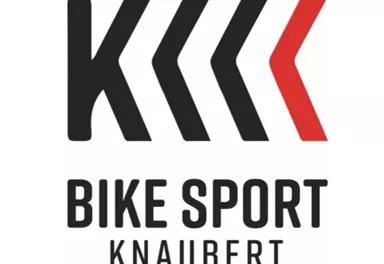 A logo for "Bike Sport Knaubert". It features stylized arrows and the lettering in clear, modern font.