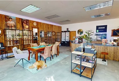 A modern designed business space with wooden walls and elegant furniture. There is a table, chairs, and a friendly atmosphere.