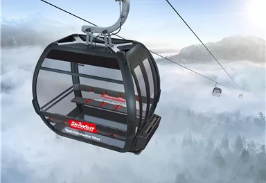 Eine moderne Gondelbahn schwebt über neblige Berge. Die Aussicht ist spektakulär und vermittelt ein Gefühl von Freiheit.