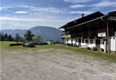 A rustic building in a picturesque landscape. In the background, there are mountains and a clear sky.