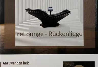 An elegant reclining chair is in a modern room with vertical lines. The chair is equipped with a display and offers relaxation for stressed people.