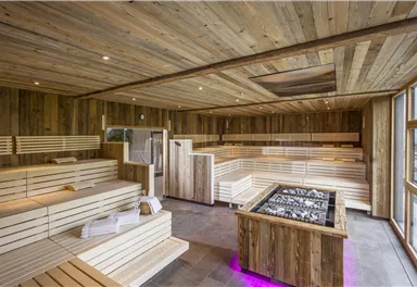A modern wellness area with wooden paneling and a sauna. The room is bright and invites relaxation.