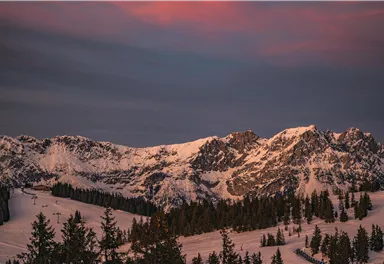 An impressive mountain landscape with snow-capped peaks and a dark sky. Soft colors of twilight give the scene a special charm.