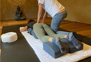 A relaxing massage session in a quiet room. In the background, a Buddha statue can be seen.