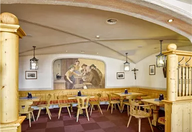 A cozy restaurant with wooden furniture and a vibrant mural. The atmosphere is inviting and traditional.